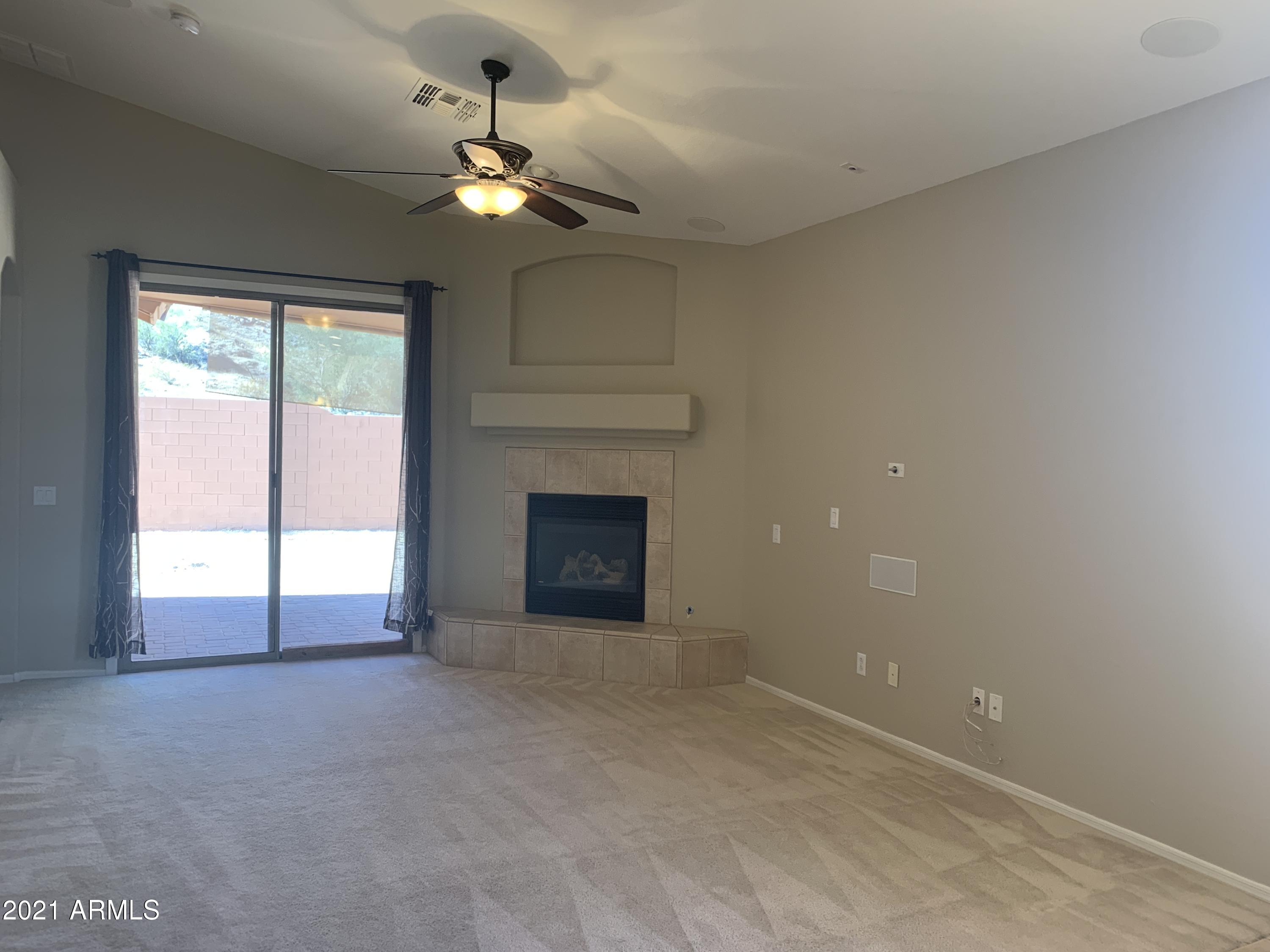 10460 South 182nd Drive Goodyear, AZ 85338 - Photo 17 of 33 a view of an empty room with a fireplace and a window