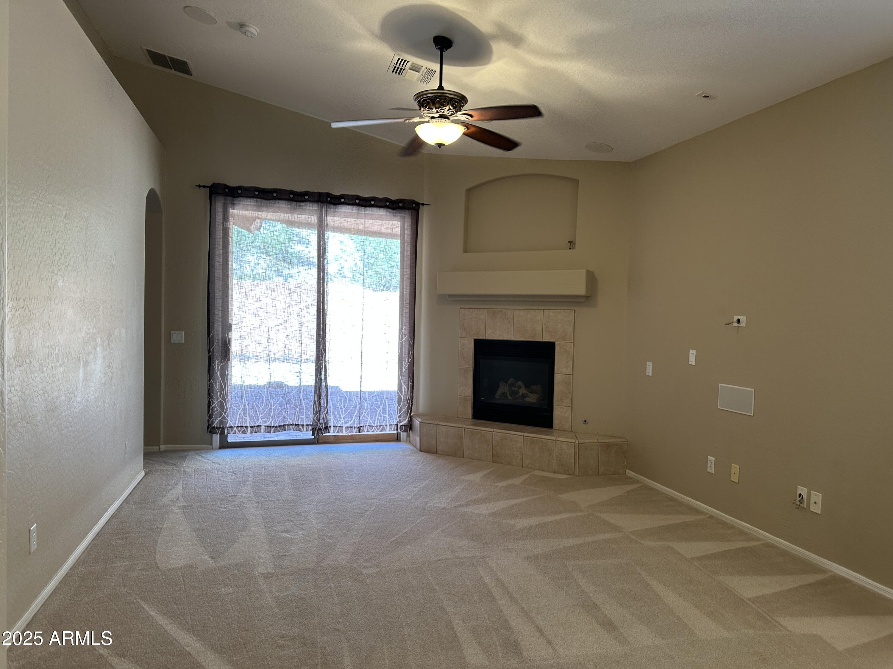 10460 South 182nd Drive Goodyear, AZ 85338 - Photo 4 of 33 a view of an empty room with a fireplace and a window