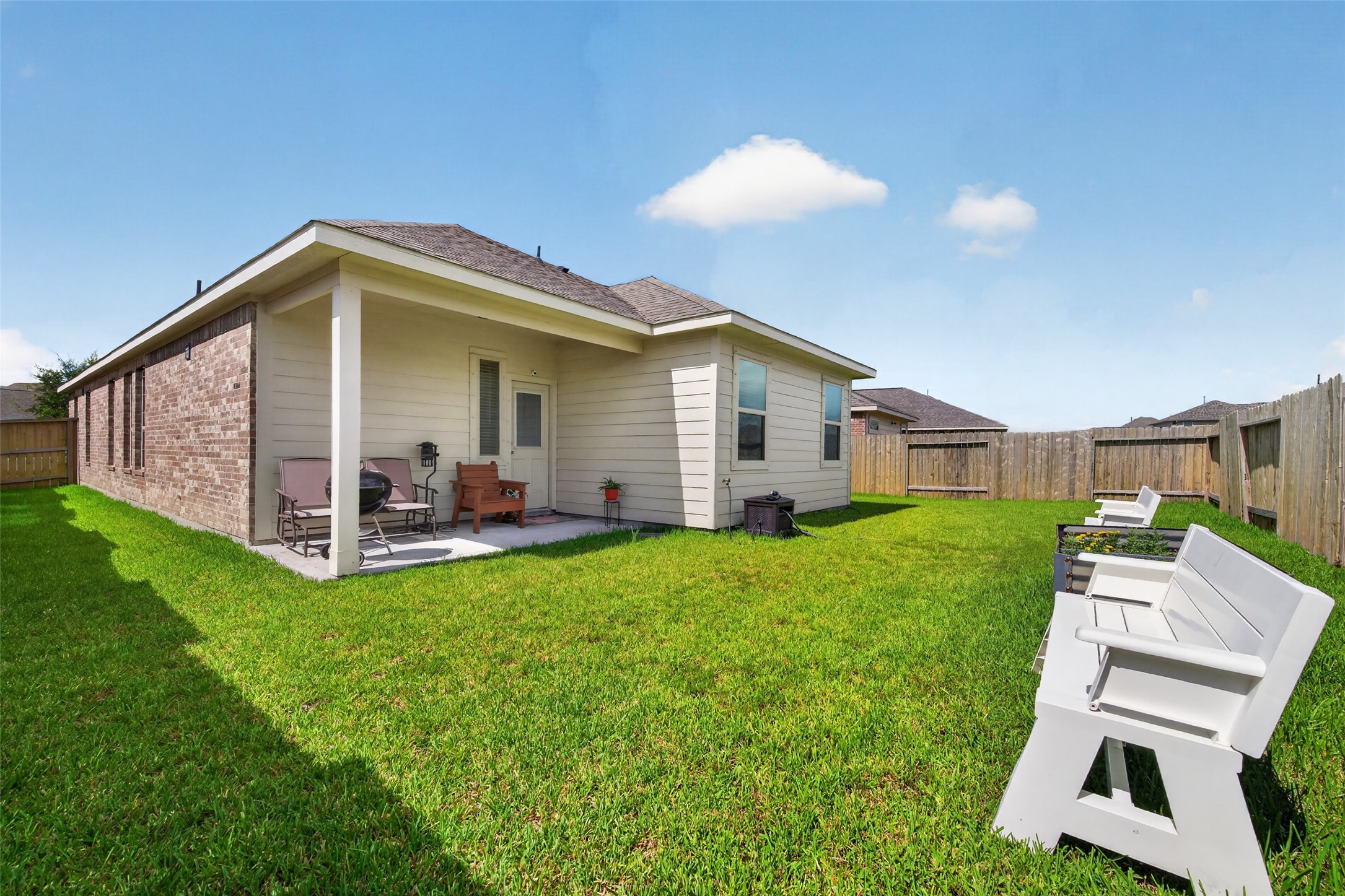 1329 Red Hills Drive Rosharon, TX 77583 - Photo 25 of 27 A backyard with a spacious, well-maintained lawn. The exterior features a combination of brick and siding.