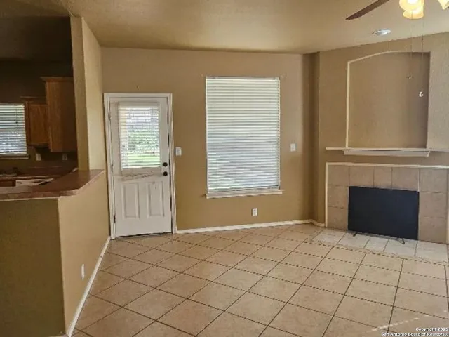 a view of an empty room with a fireplace and a window