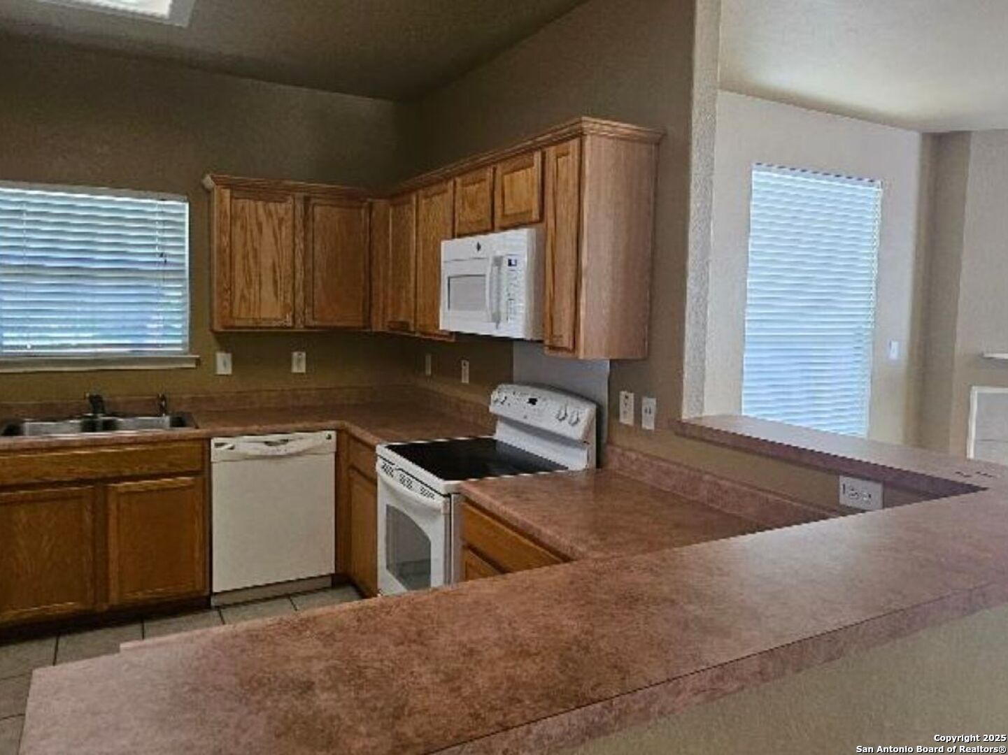 9019 Burnt Peak Helotes, TX 78023 - Photo 5 of 11 a kitchen with stainless steel appliances granite countertop a stove a sink and a microwave