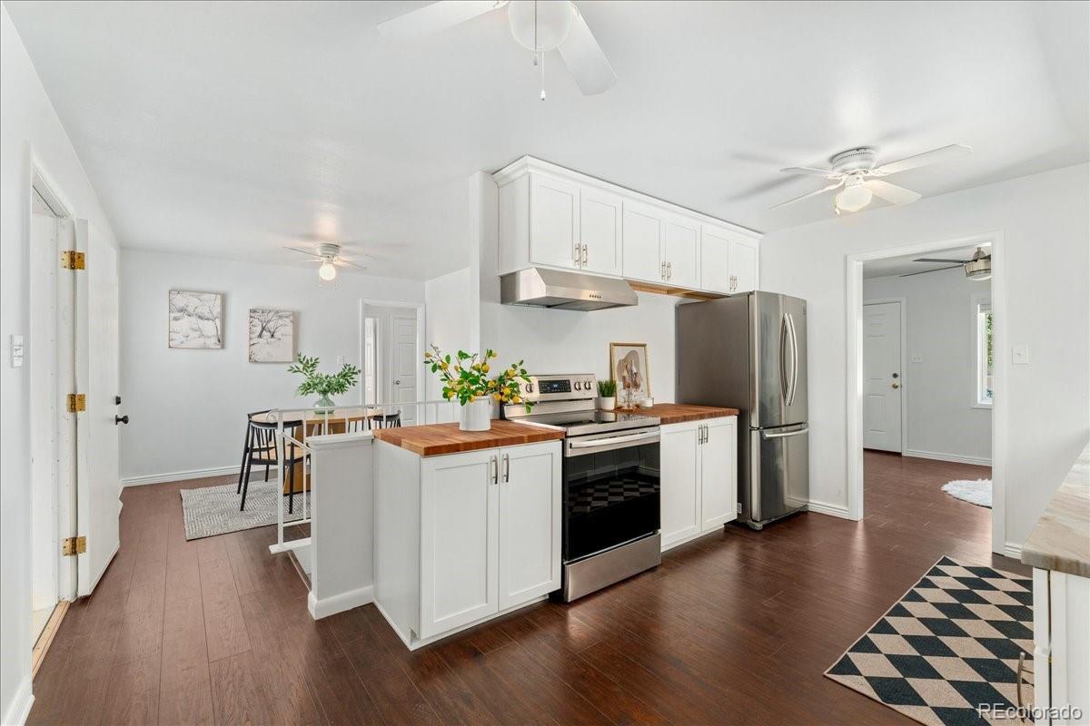 2597 South Perry Street Denver, CO 80219 - Photo 10 of 33 a kitchen with white cabinets and stainless steel appliances