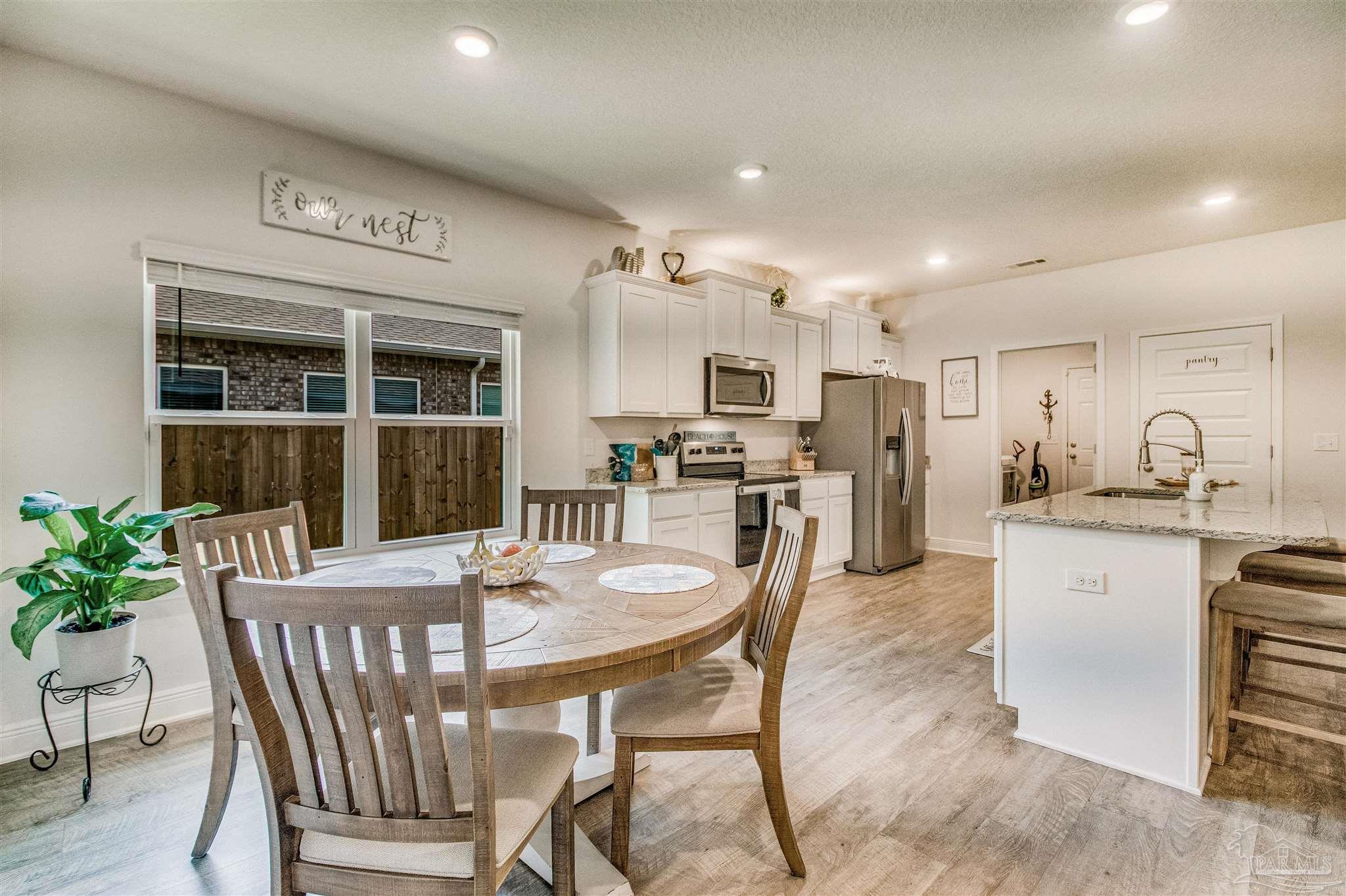 8024 Silver Maple Drive Milton, FL 32583 - Photo 11 of 43 a view of a dining room with furniture and a potted plant