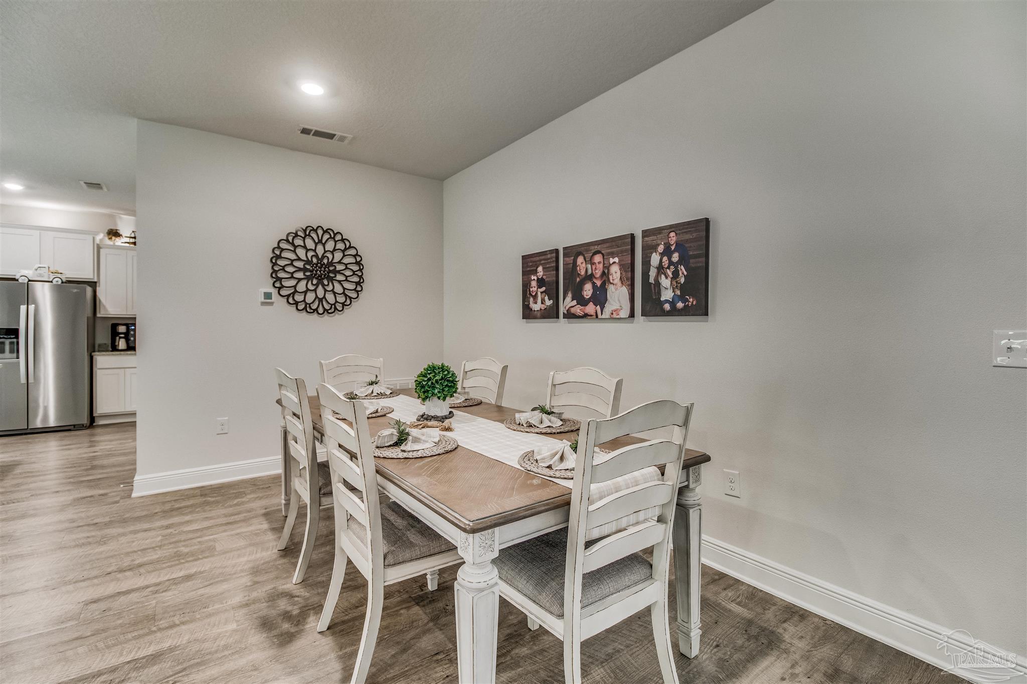 8024 Silver Maple Drive Milton, FL 32583 - Photo 12 of 43 a view of a dining room with furniture and wooden floor