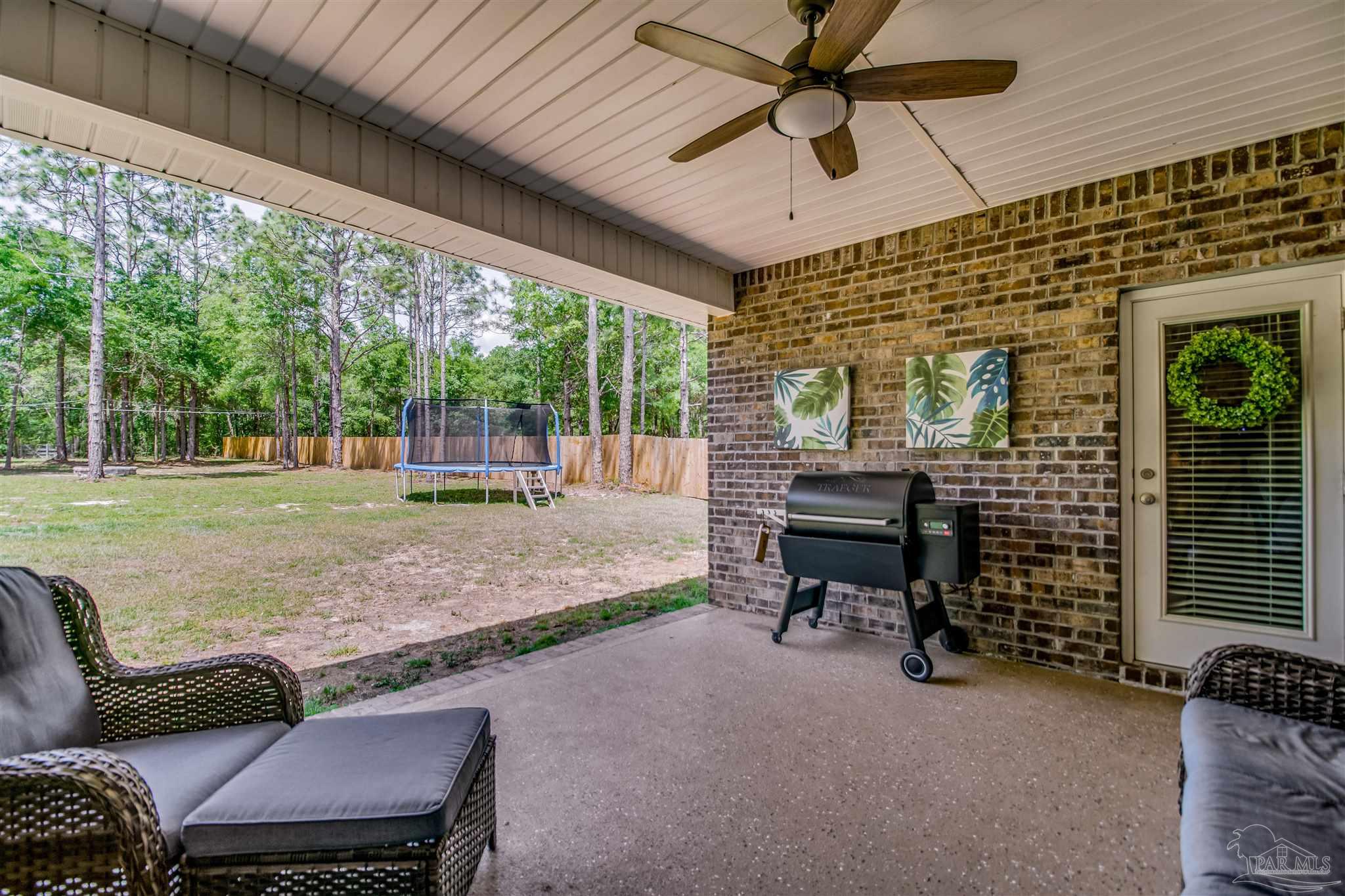 8024 Silver Maple Drive Milton, FL 32583 - Photo 20 of 43 a backyard of a house with barbeque oven table and chairs