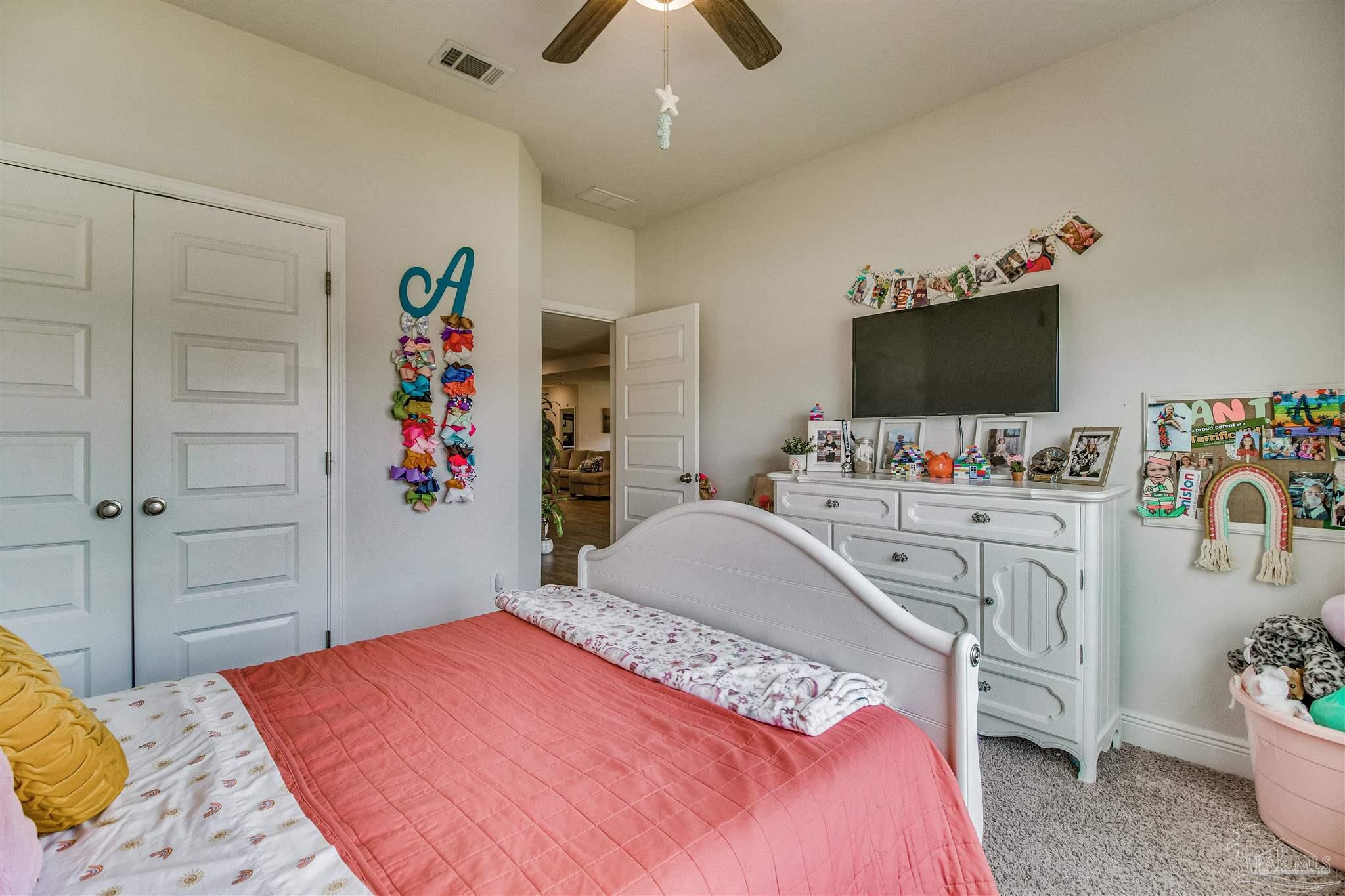 8024 Silver Maple Drive Milton, FL 32583 - Photo 24 of 43 a bedroom with a bed and a tv