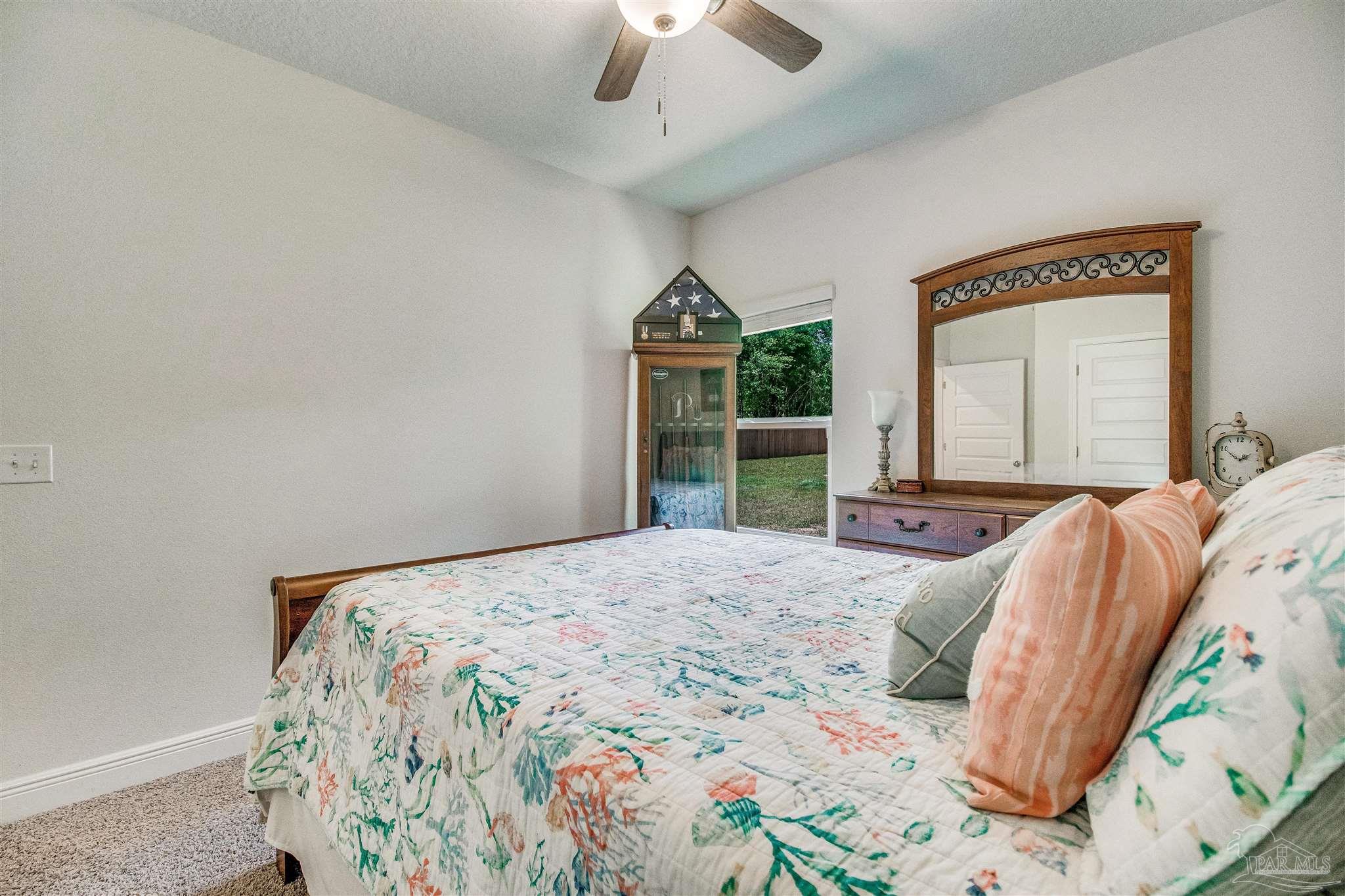 8024 Silver Maple Drive Milton, FL 32583 - Photo 27 of 43 a bedroom with a bed and a chandelier