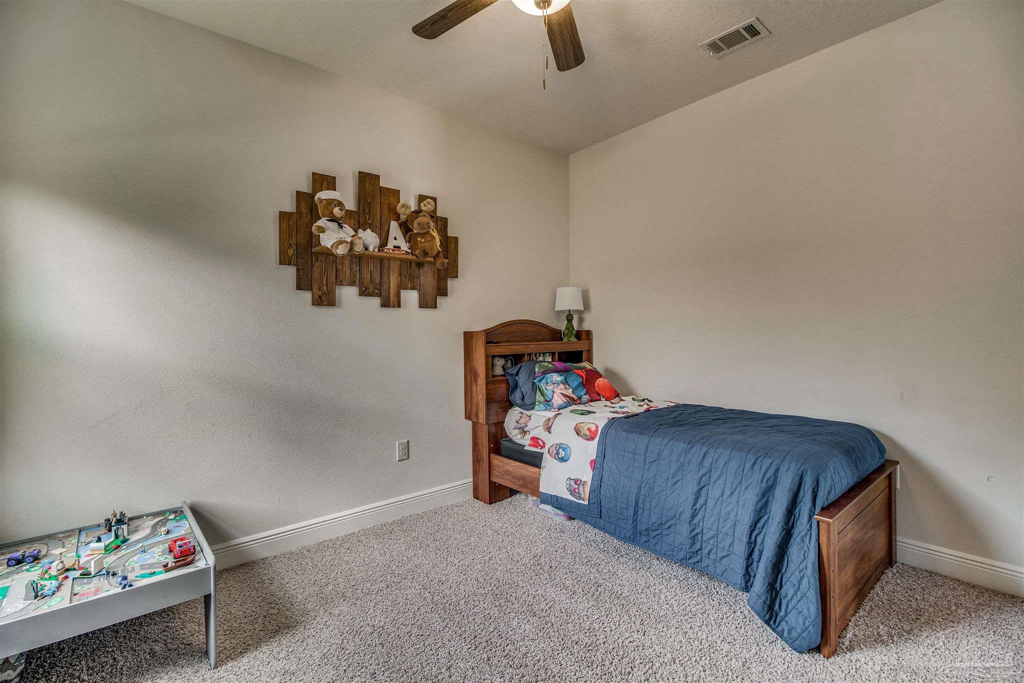 8024 Silver Maple Drive Milton, FL 32583 - Photo 34 of 43 a bedroom with a bed and a chandelier