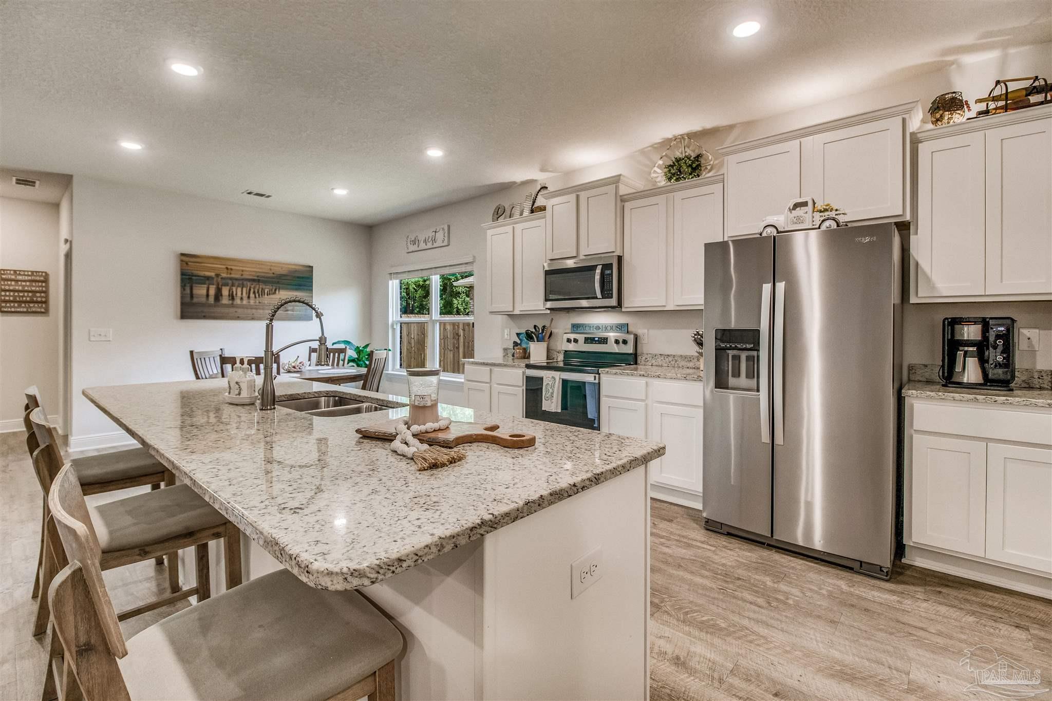 8024 Silver Maple Drive Milton, FL 32583 - Photo 4 of 43 a kitchen with stainless steel appliances granite countertop a sink refrigerator and microwave