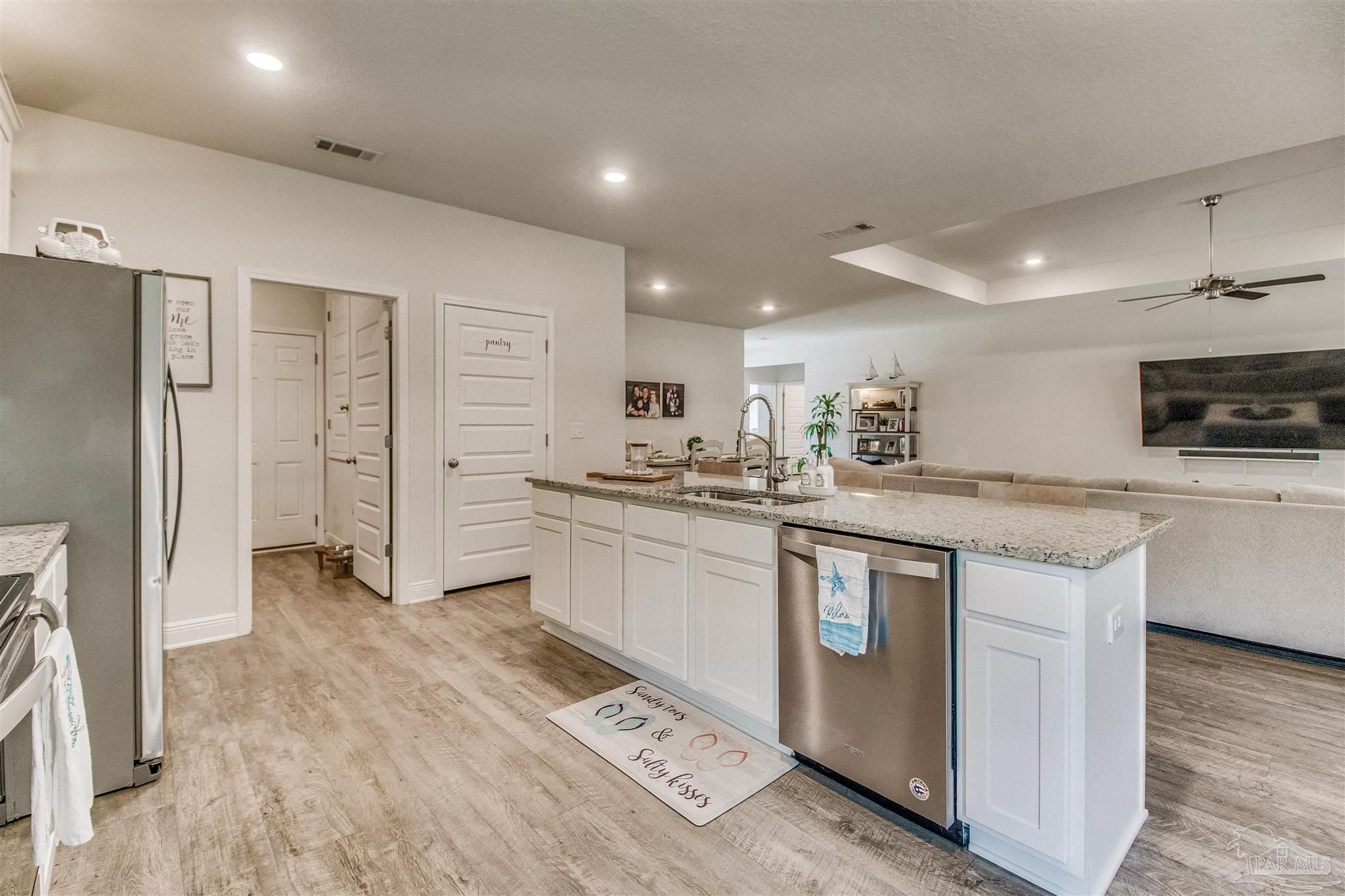 8024 Silver Maple Drive Milton, FL 32583 - Photo 7 of 43 a kitchen with stainless steel appliances granite countertop a refrigerator a sink a stove and white cabinets