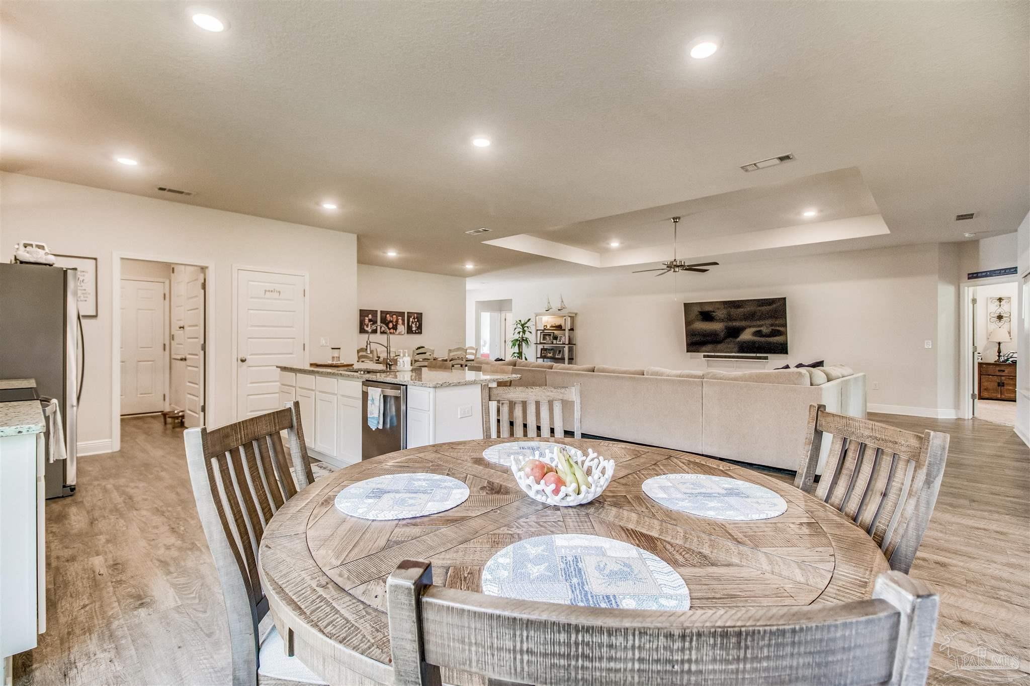 8024 Silver Maple Drive Milton, FL 32583 - Photo 10 of 43 a dining room with furniture and a dining table with kitchen view