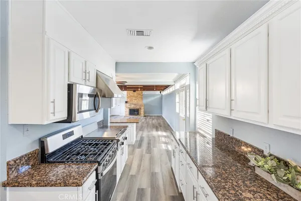 a kitchen with granite countertop lots of counter top space and wooden floor