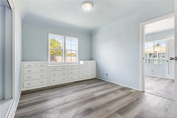 an empty room with windows and cabinet