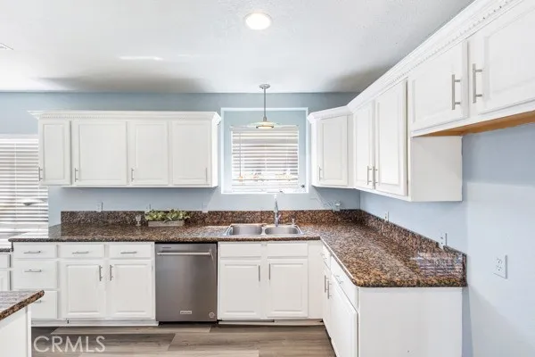a kitchen with granite countertop white cabinets and white appliances