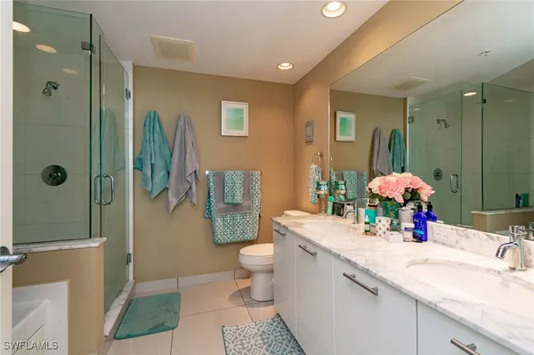 a bathroom with a sink double vanity mirror and toilet