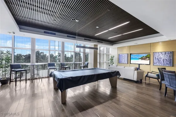 a living room with stainless steel appliances granite countertop furniture wooden floor and a large window