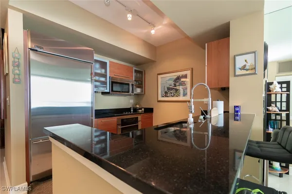 a kitchen with stainless steel appliances granite countertop a sink a stove and a refrigerator