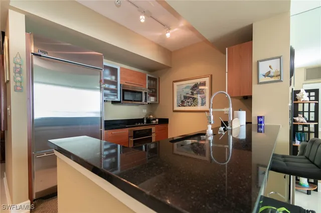 a kitchen with stainless steel appliances granite countertop a sink a stove and a refrigerator