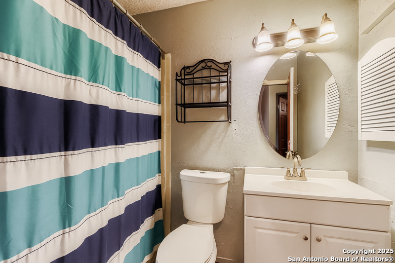 2518 Ridge Leaf San Antonio, TX 78251 - Photo 16 of 19 a bathroom with a toilet a sink and mirror