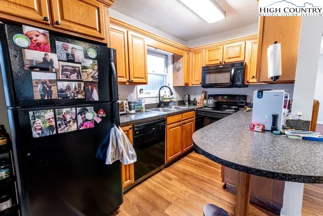 a kitchen with stainless steel appliances granite countertop a sink a stove and a refrigerator