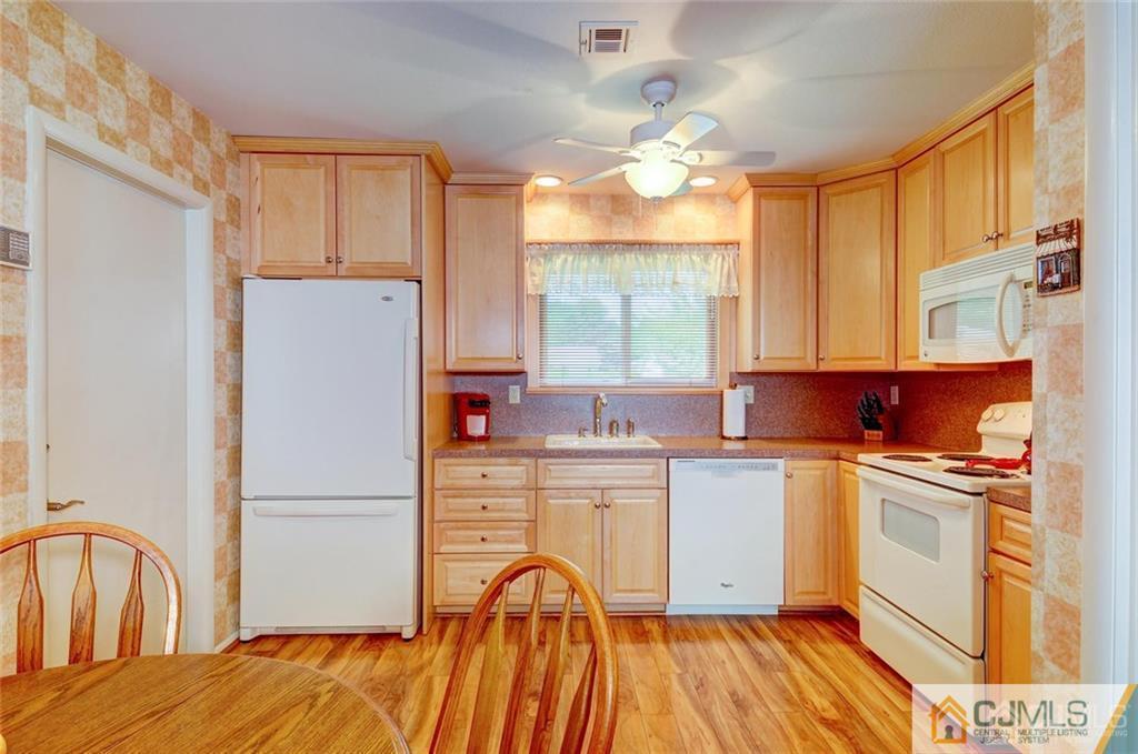 781 A Risley Road Monroe Township, NJ 08831 - Photo 8 of 21 a kitchen with a refrigerator a stove a sink dishwasher and wooden cabinets with wooden floor