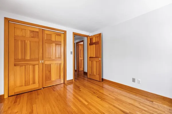 an empty room with wooden floor and sliding door