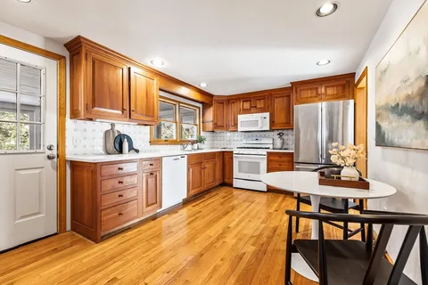 a kitchen with a table chairs stove and cabinets