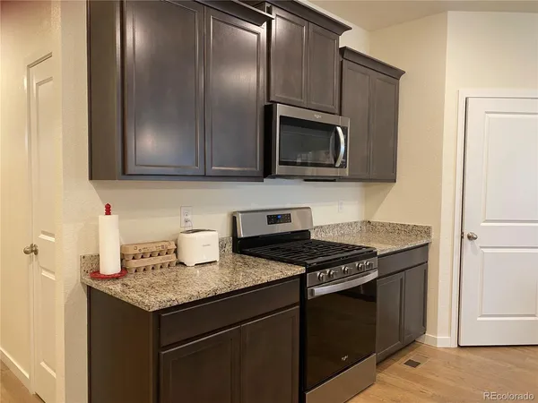 a kitchen with granite countertop stainless steel appliances and wooden cabinets