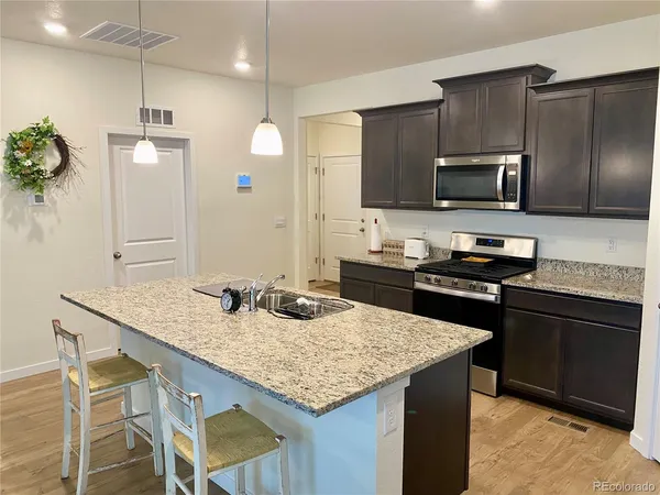 a kitchen with kitchen island granite countertop a sink and stainless steel appliances