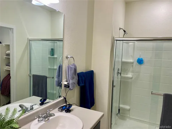 a bathroom with a sink vanity granite tub and shower