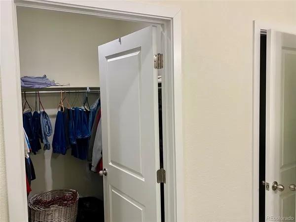 a view of walk in closet with clothes and shoes
