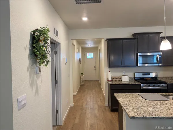 a kitchen with granite countertop kitchen island stainless steel appliances a refrigerator a stove a microwave a sink and cabinets