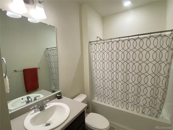 a bathroom with a sink a toilet and shower curtain