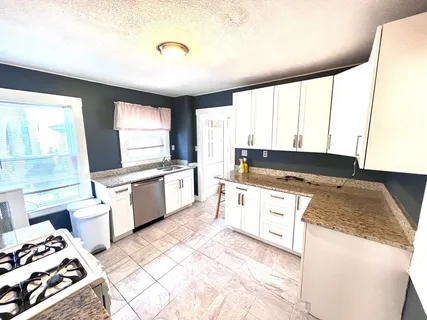 a kitchen with a stove a sink and a window