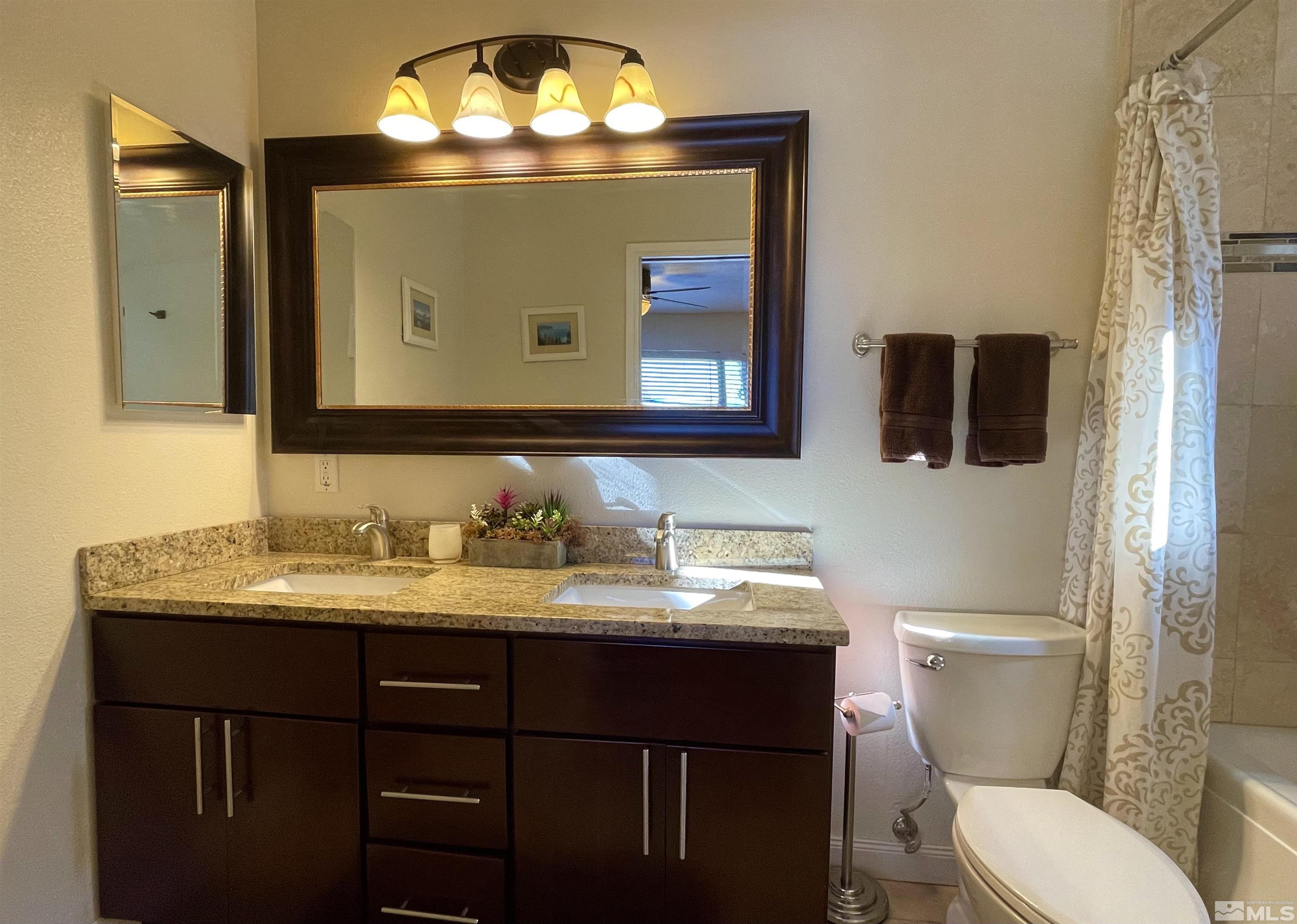 126 Spooner Lane, Unit B Stateline, NV 89449 - Photo 13 of 37 a bathroom with a granite countertop toilet sink and mirror
