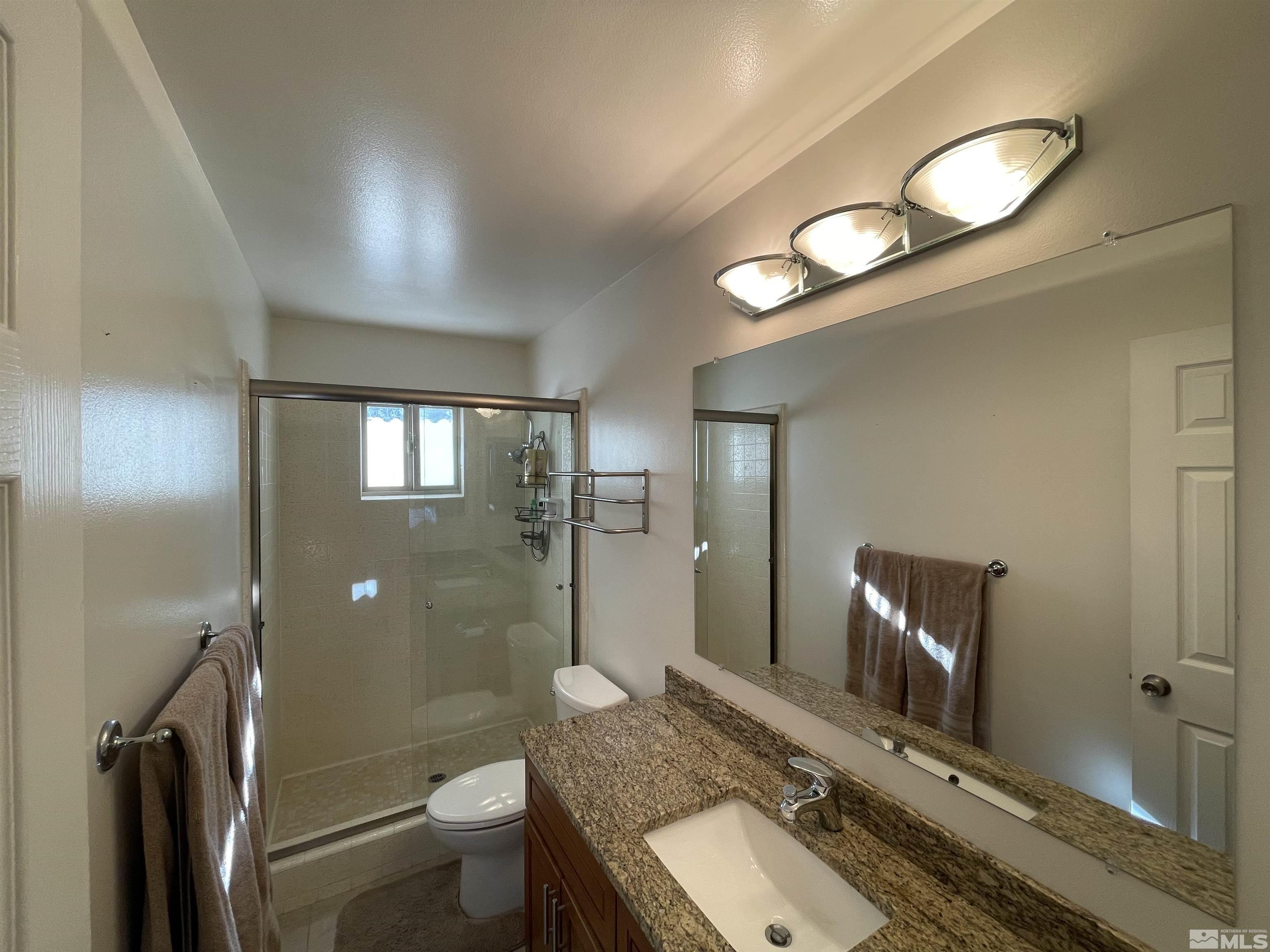 126 Spooner Lane, Unit B Stateline, NV 89449 - Photo 16 of 37 a bathroom with a granite countertop sink toilet and shower