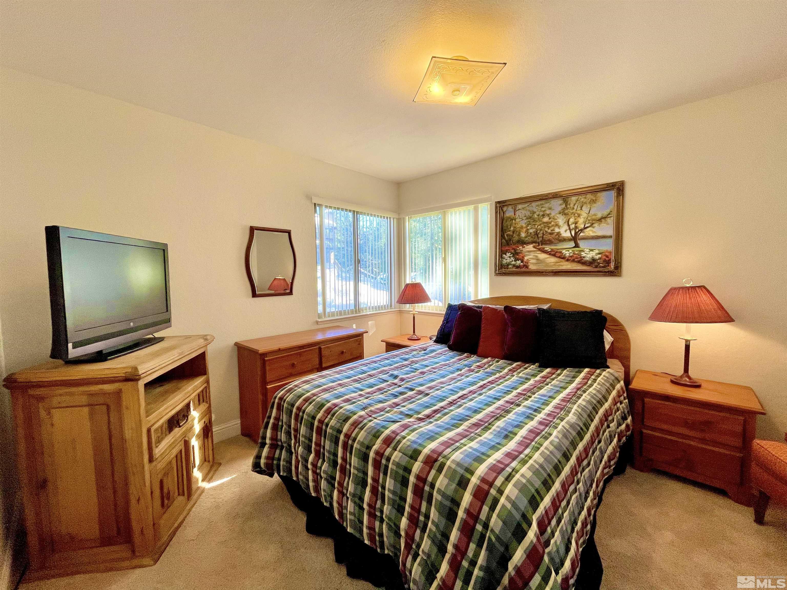 126 Spooner Lane, Unit B Stateline, NV 89449 - Photo 18 of 37 a bedroom with a bed and a flat screen tv