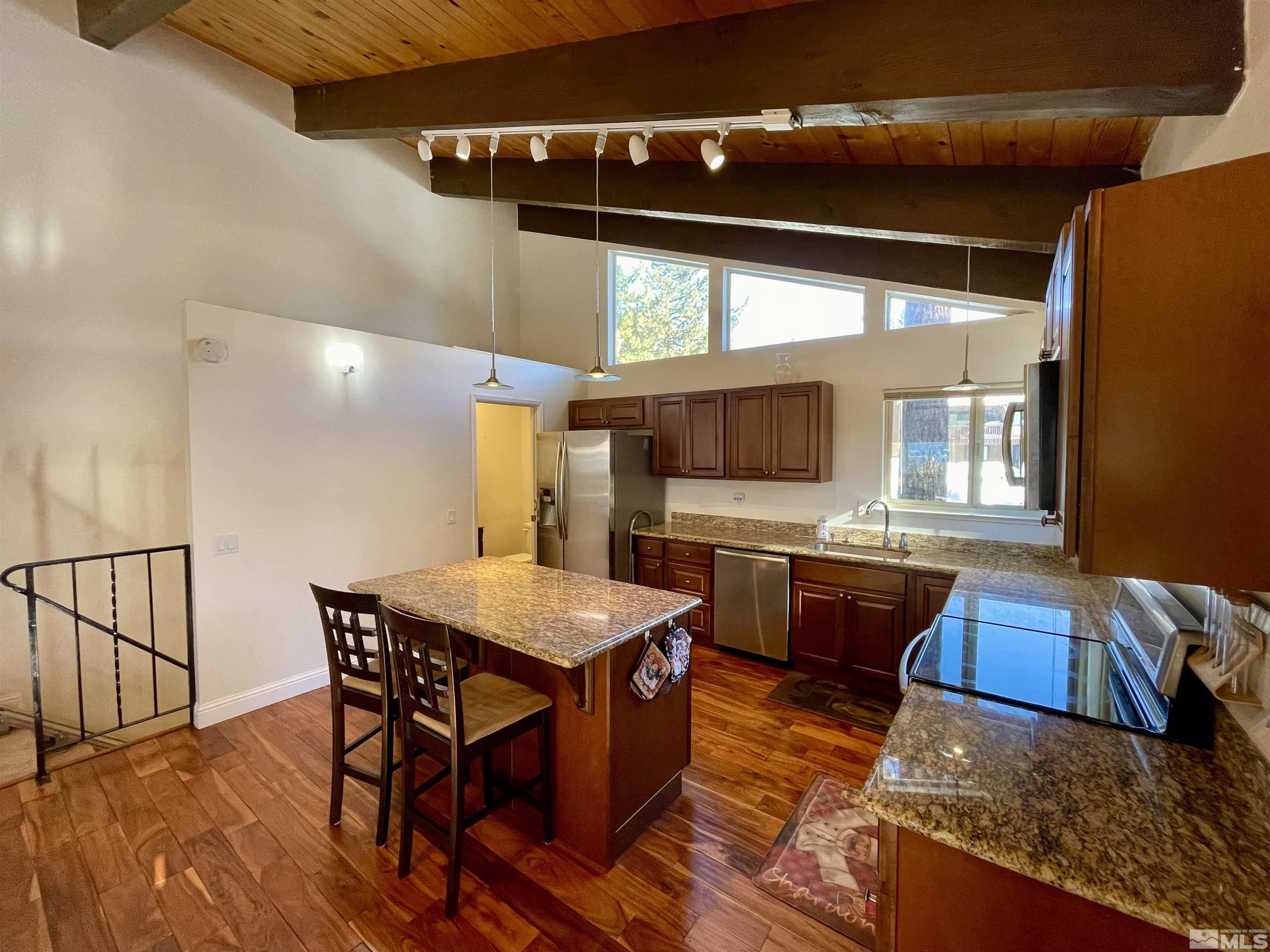 126 Spooner Lane, Unit B Stateline, NV 89449 - Photo 5 of 37 a kitchen with stainless steel appliances granite countertop a sink counter space and chairs