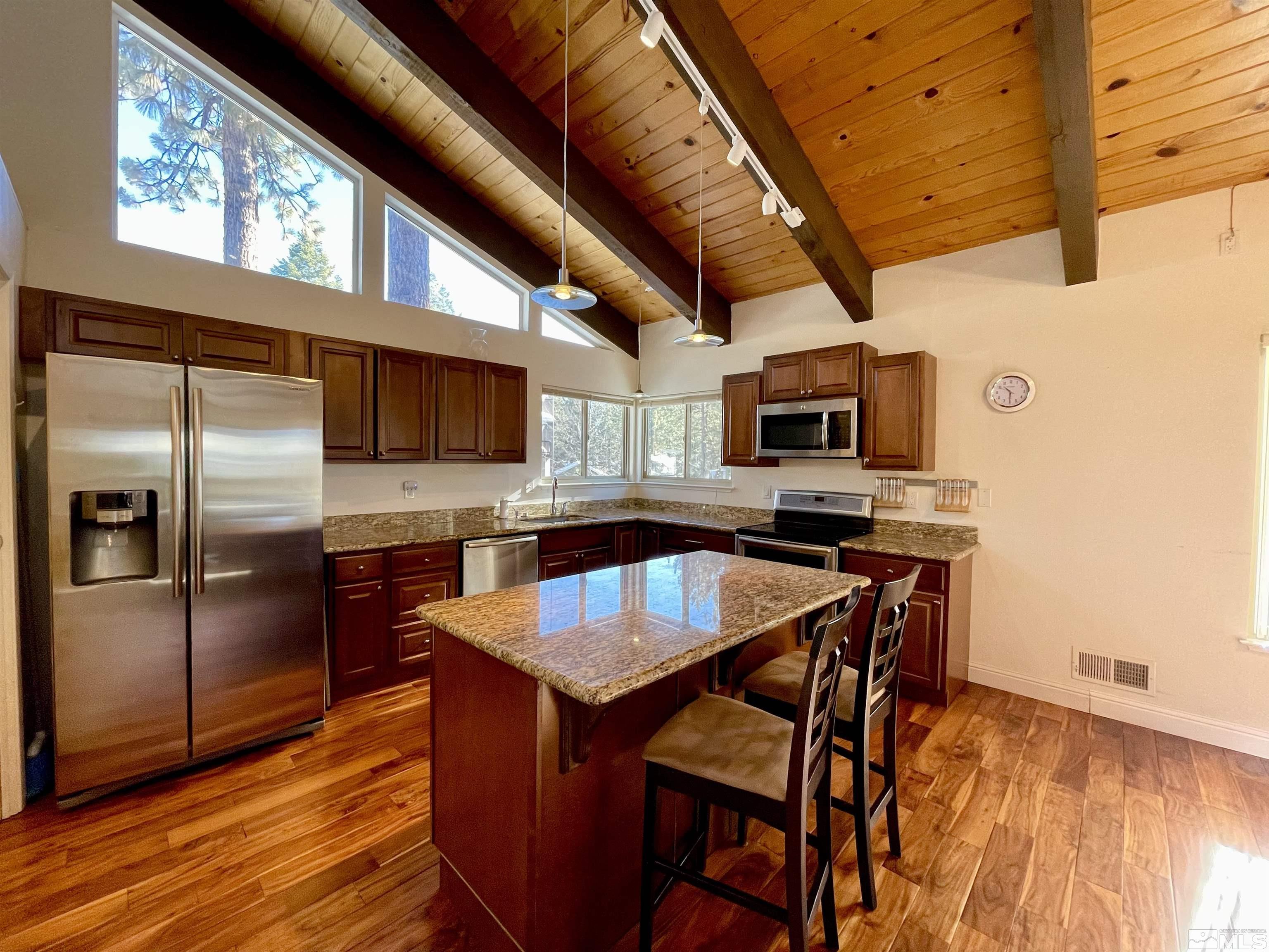 126 Spooner Lane, Unit B Stateline, NV 89449 - Photo 8 of 37 a kitchen with stainless steel appliances granite countertop a stove a sink dishwasher and a refrigerator with wooden floor