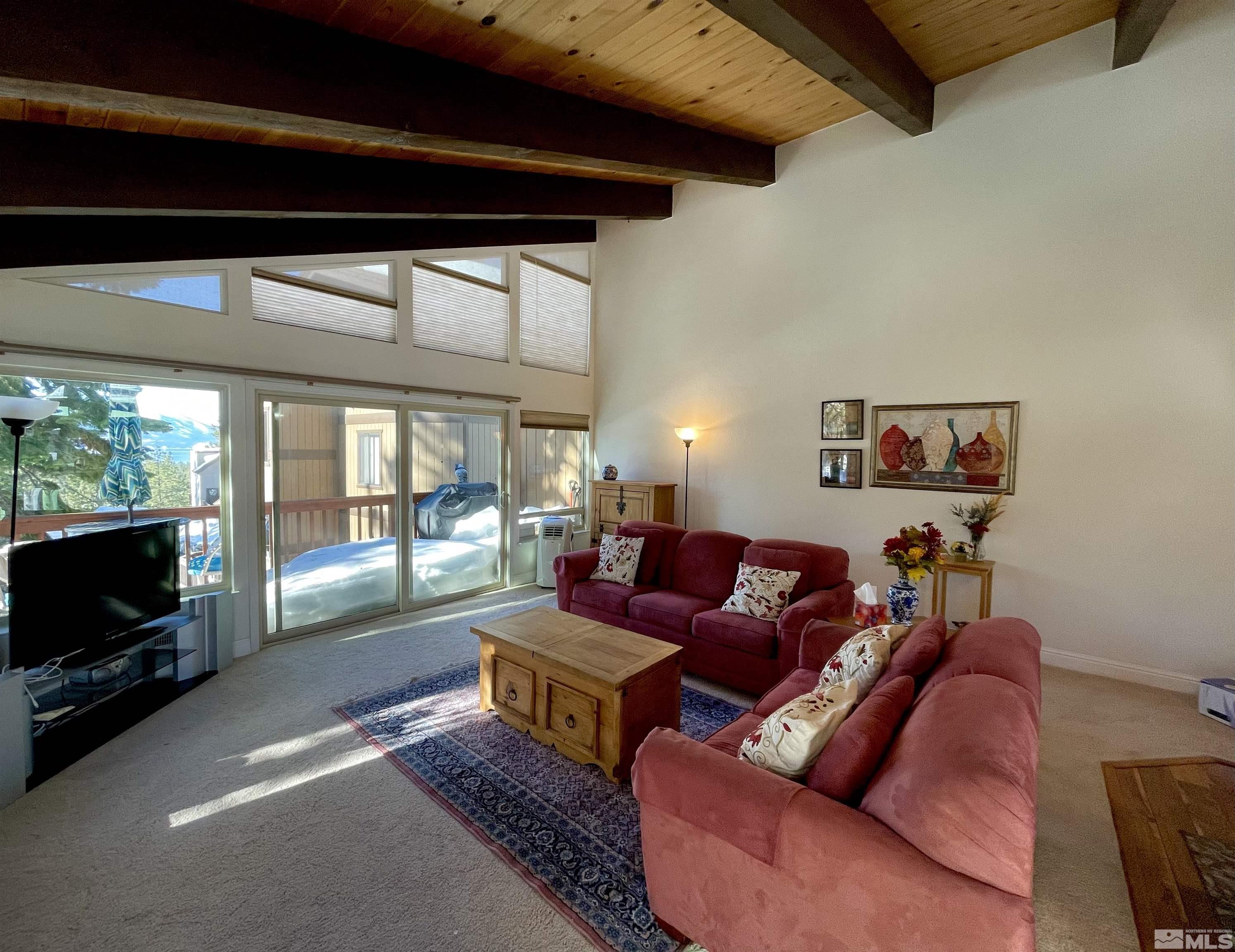 126 Spooner Lane, Unit B Stateline, NV 89449 - Photo 10 of 37 a living room with furniture a flat screen tv and a floor to ceiling window