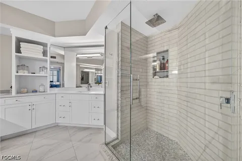 a spacious bathroom with a granite countertop sink a mirror and shower