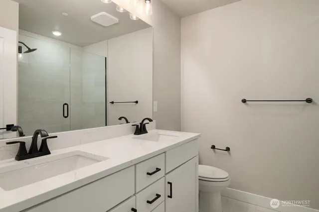 a bathroom with a sink a toilet and a mirror
