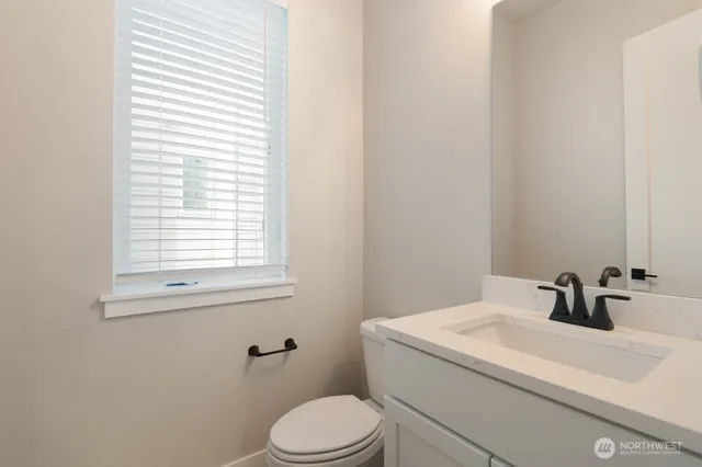 a bathroom with a sink a toilet and a window