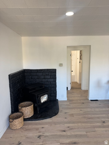47 B Street Helper, UT 84526 - Photo 7 of 19 Corner brick fireplace with a black painted finish and an inserted wood-burning stove