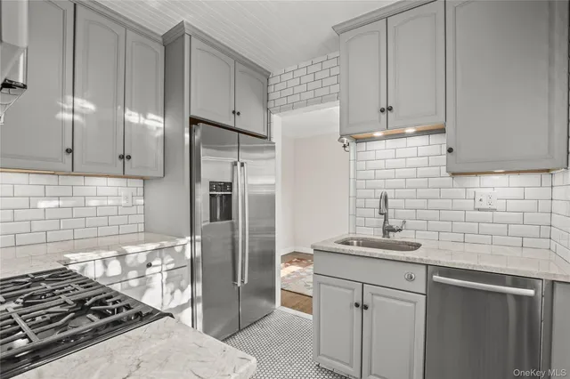 a kitchen with stainless steel appliances a stove a sink and a refrigerator