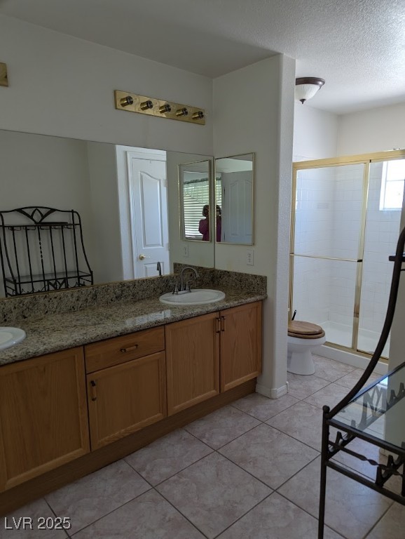 4777 Crakow Court Las Vegas, NV 89147 - Photo 18 of 49 Full bathroom with double vanity, a shower stall, a textured ceiling, light tile patterned flooring, and healthy amount of natural light