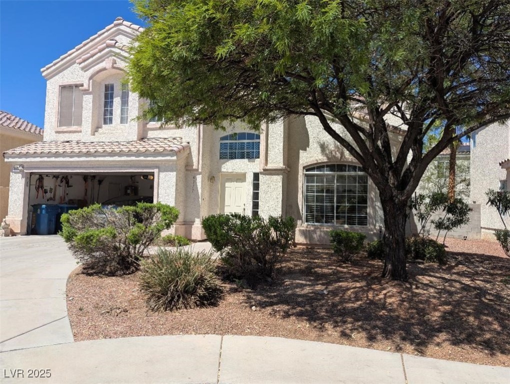 4777 Crakow Court Las Vegas, NV 89147 - Photo 2 of 49 View of front facade featuring concrete driveway, stucco siding, a garage, and a tiled roof