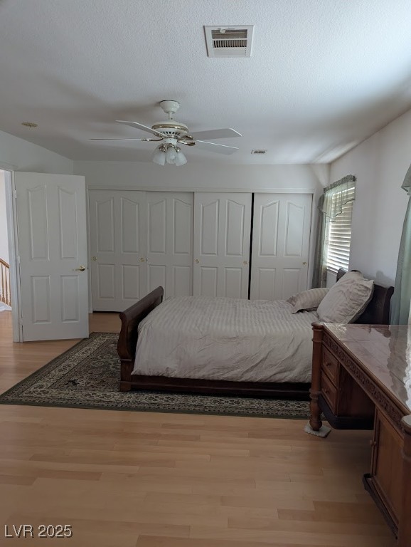 4777 Crakow Court Las Vegas, NV 89147 - Photo 21 of 49 Bedroom with light wood-style flooring, a ceiling fan, and a textured ceiling