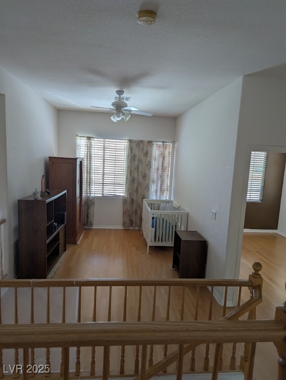 4777 Crakow Court Las Vegas, NV 89147 - Photo 23 of 49 Stairway with wood finished floors, healthy amount of natural light, a textured ceiling, and a ceiling fan