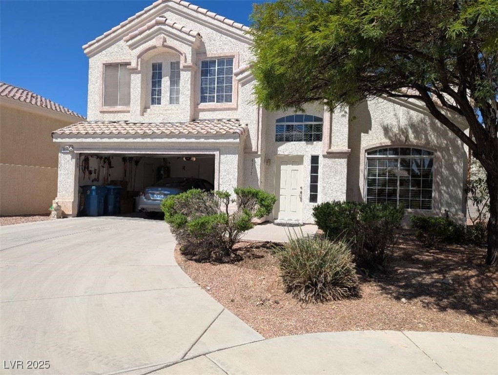 4777 Crakow Court Las Vegas, NV 89147 - Photo 3 of 49 Mediterranean / spanish-style house featuring concrete driveway, stucco siding, a garage, and a tile roof